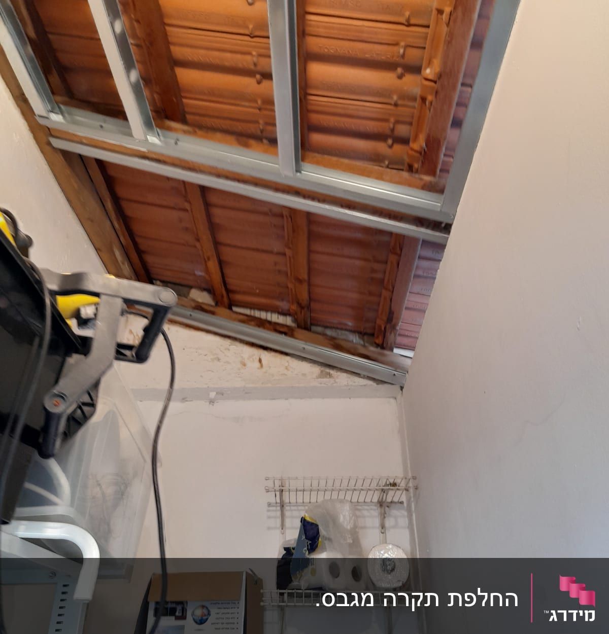 קיר גבס עם מדף מתכת ומוצרי ניקוי